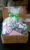A plastic bag with a green ribbon inside, a woven basket