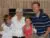 A family of four posing together indoors in front of a brick wall.