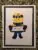 A Minion holding a 'HELLO' sign in a framed picture.