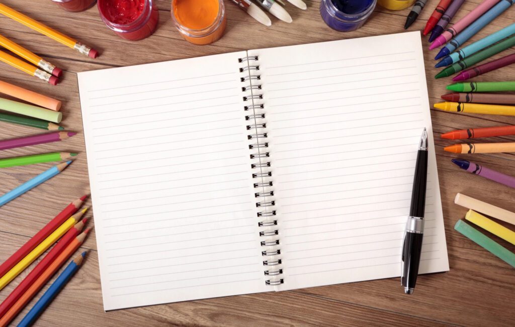 Open spiral notebook with blank lined pages and a pen beside it.