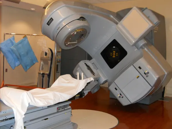 Technician operating a medical linear accelerator for radiation therapy.