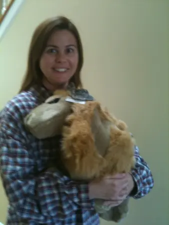 Woman holding two rabbits, smiling.